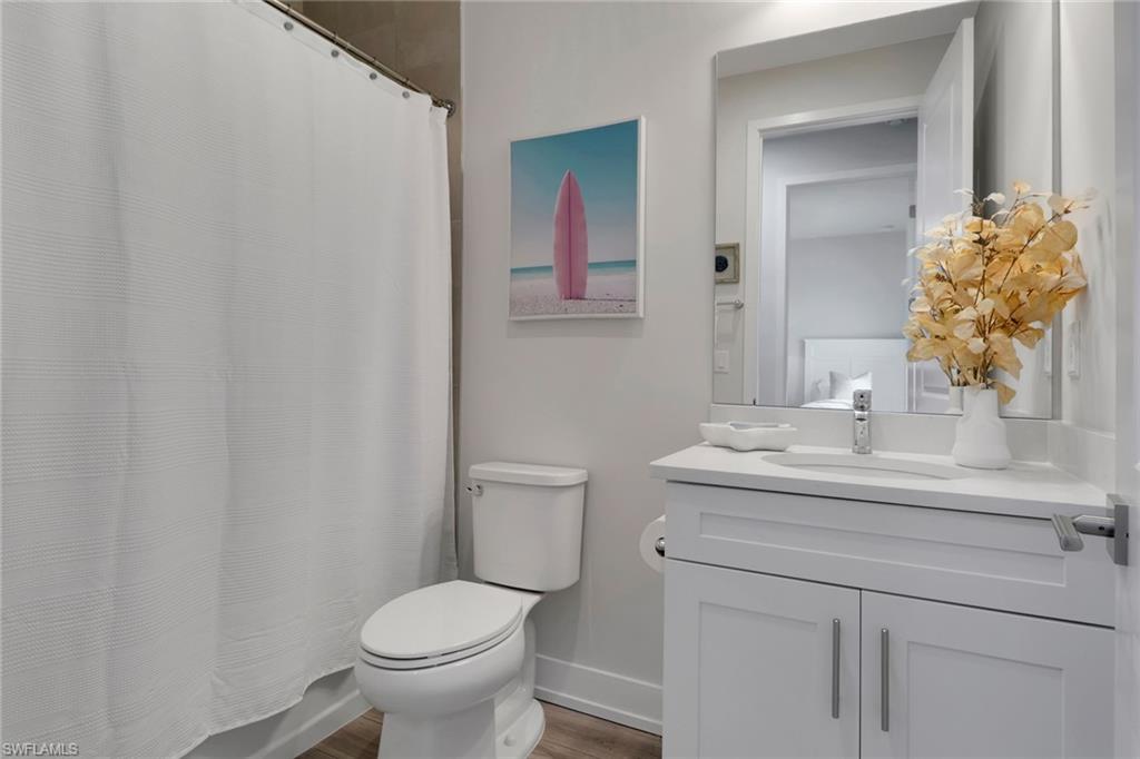 Bathroom featuring vanity, wood finished floors, and shower / bath combo