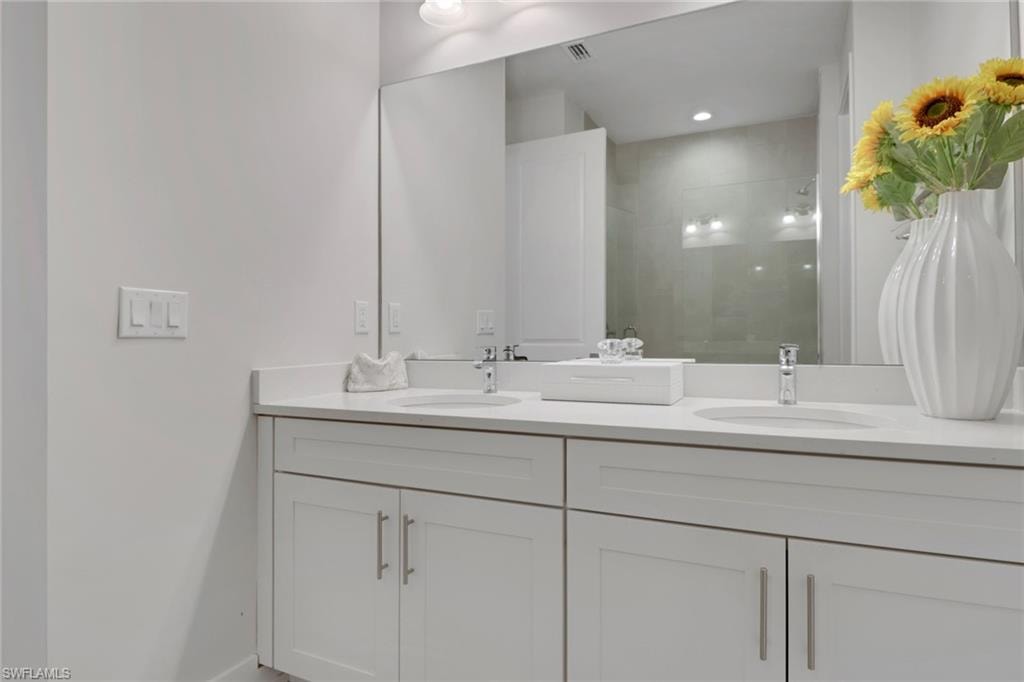 Full bath featuring a walk in shower and double vanity