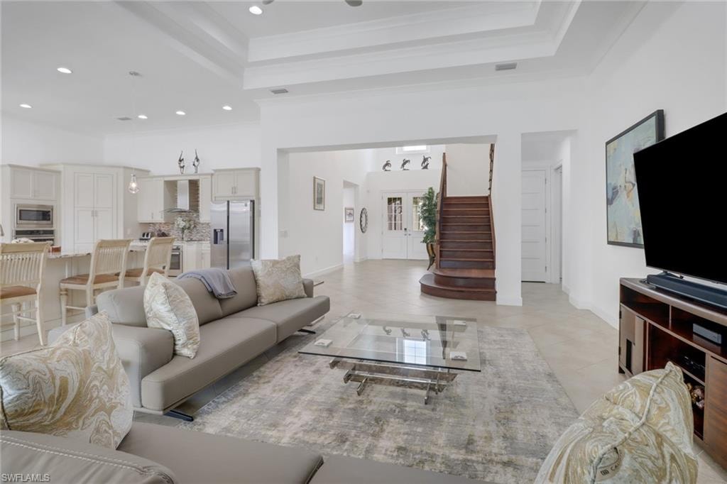 Living room featuring light tile patterned floors and a tray ceiling