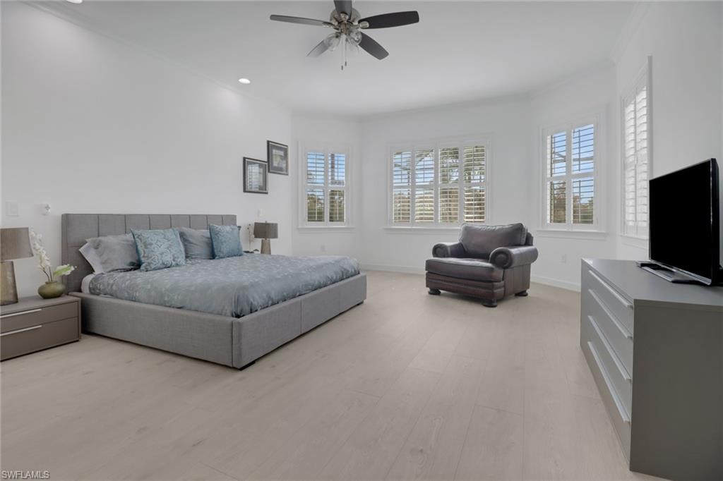 Bedroom with crown molding, light hardwood / wood-style floors, and ceiling fan