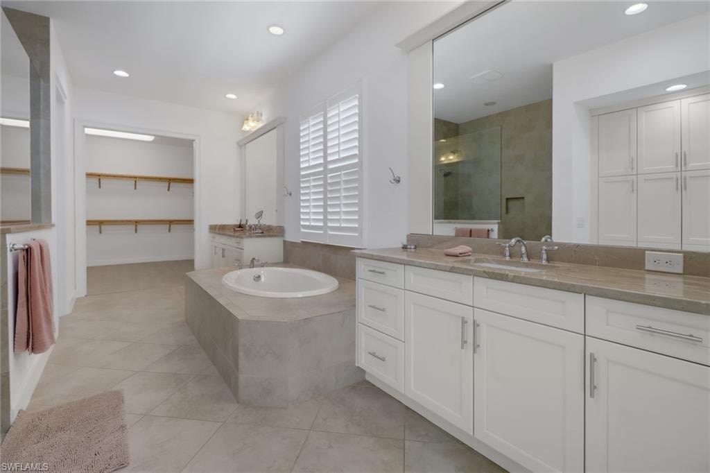 Bathroom featuring vanity, separate shower and tub, and tile patterned flooring