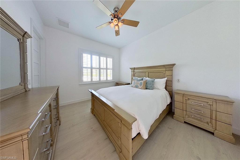 Bedroom featuring ceiling fan, vaulted ceiling, and light hardwood / wood-style flooring