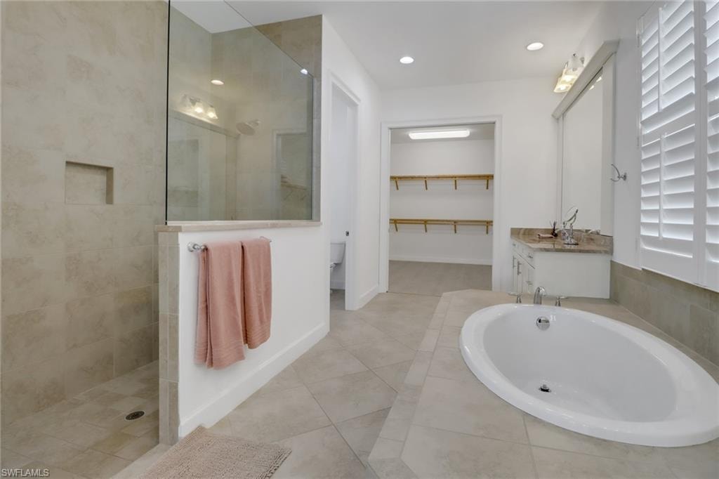 Bathroom featuring vanity, separate shower and tub, and tile patterned flooring