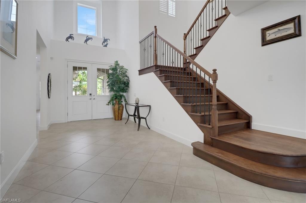 Tiled foyer featuring french doors and a high ceiling