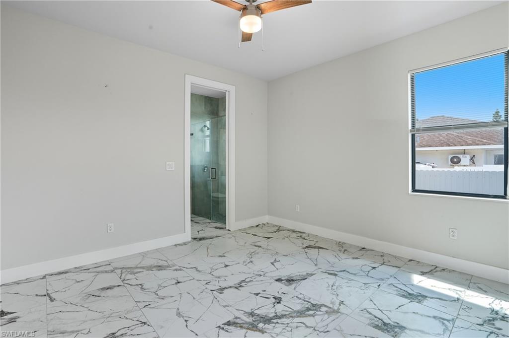 Unfurnished room with light marble finish flooring and a ceiling fan