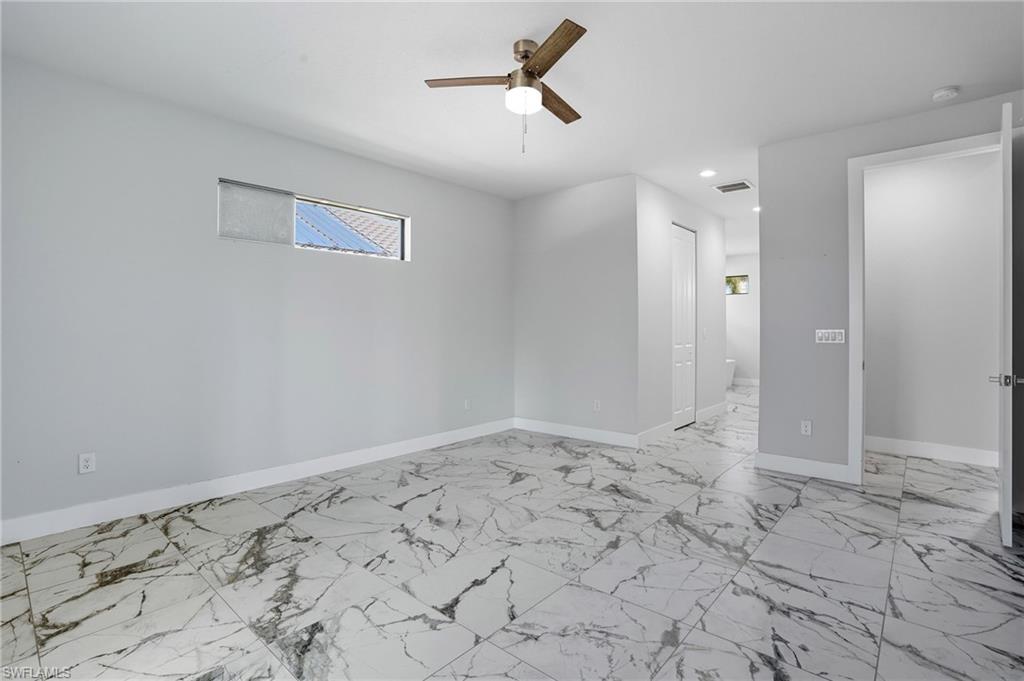 Unfurnished room with light marble finish floors and a ceiling fan
