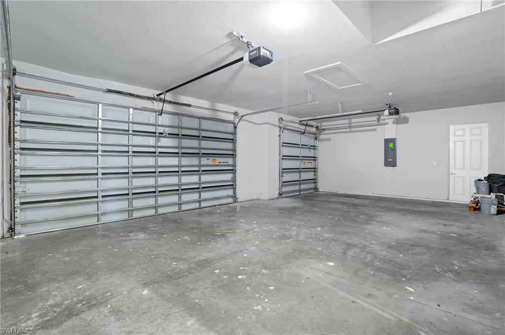 Garage featuring electric panel and a garage door opener