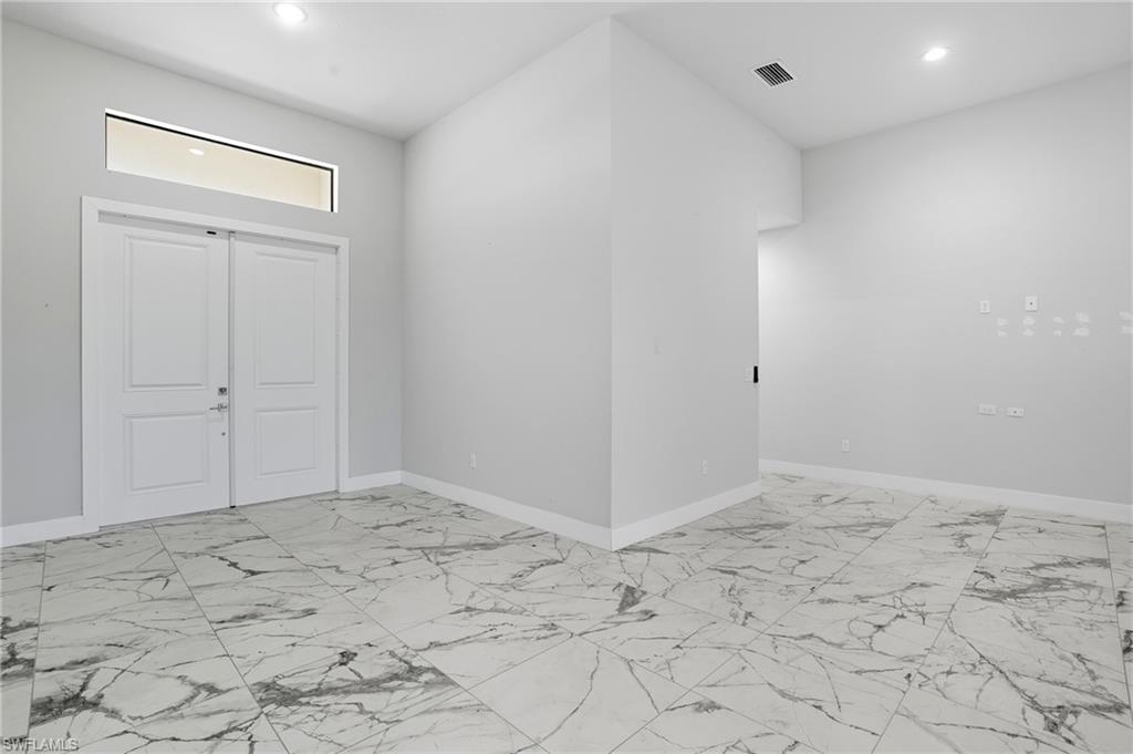 Entrance foyer featuring light marble finish flooring and recessed lighting