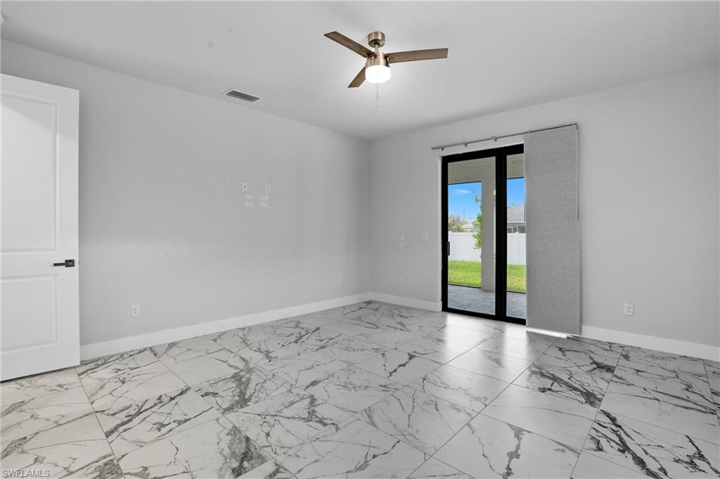Empty room with light marble finish floors and a ceiling fan