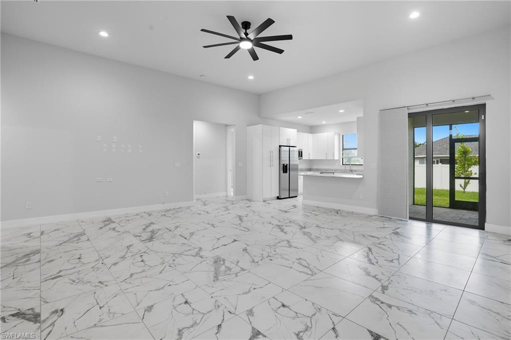 Unfurnished living room with recessed lighting, light marble finish flooring, and a ceiling fan