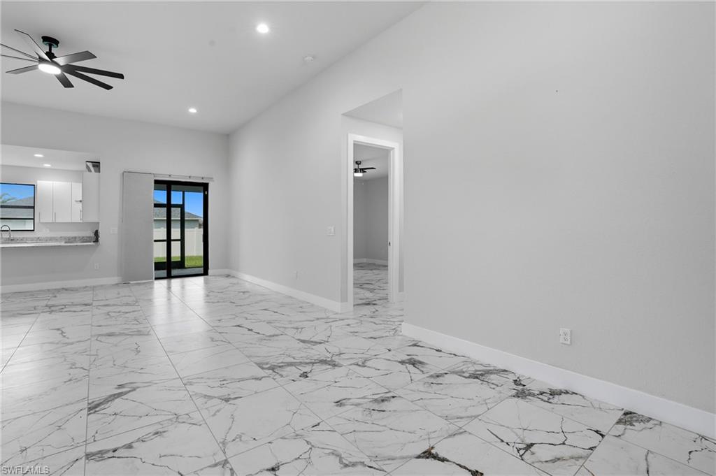 Spare room featuring light marble finish floors, ceiling fan, and recessed lighting
