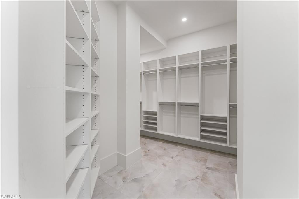 Walk in closet with light marble finish flooring