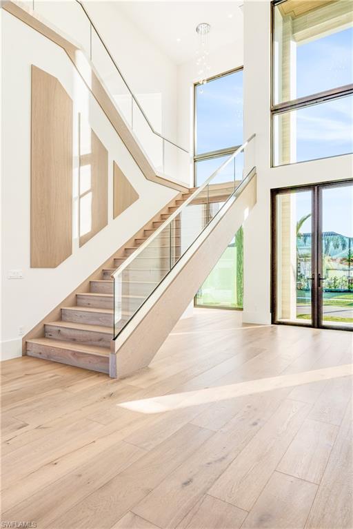 Stairs with a high ceiling and hardwood / wood-style floors