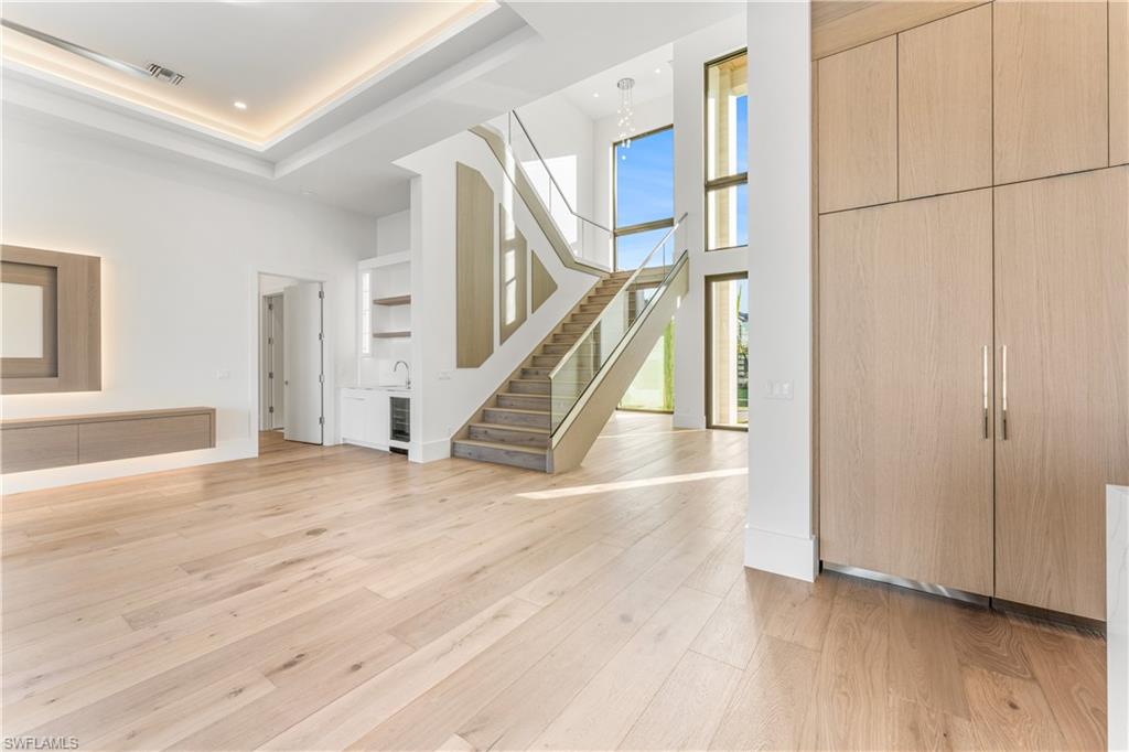 Foyer featuring a high ceiling, light wood-style flooring, beverage cooler, and recessed lighting