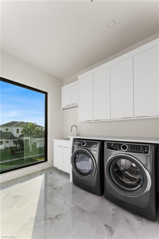 Laundry area featuring cabinet space, washer and dryer, and recessed lighting