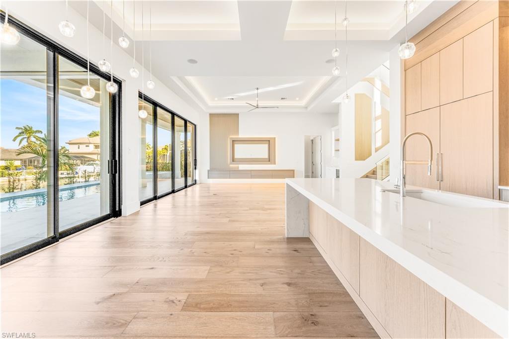 Hall featuring a tray ceiling and light wood finished floors