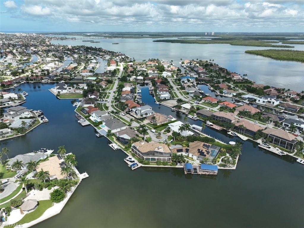 Aerial view of property and surrounding area with a large body of water and nearby suburban area