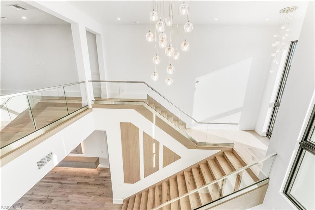 Stairs with wood finished floors and recessed lighting