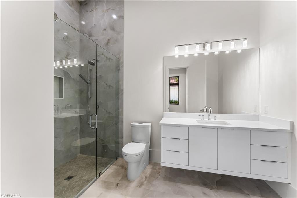 Full bath featuring vanity and a marble finish shower