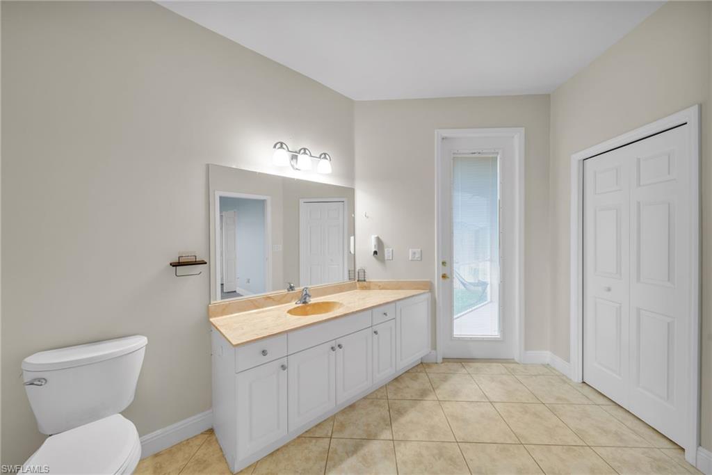 Bathroom with vanity, light tile patterned flooring, and a closet