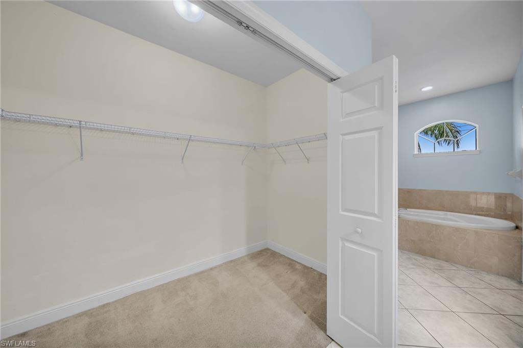 Spacious closet featuring light tile patterned flooring and light colored carpet
