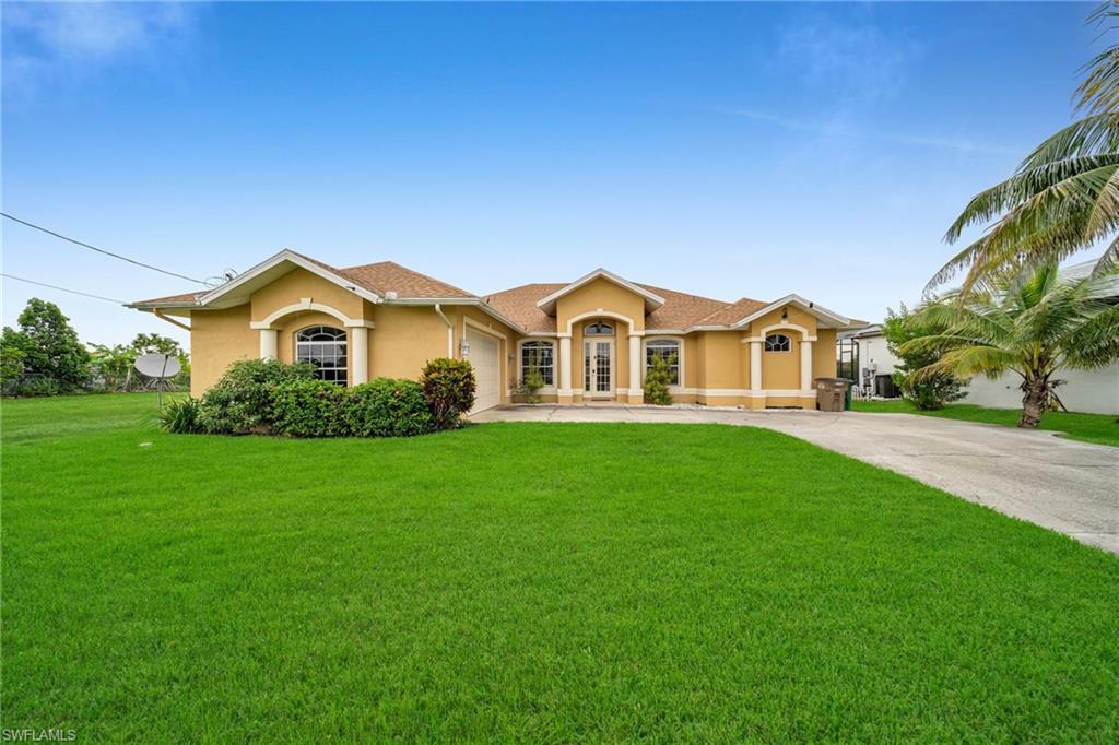 View of front facade featuring stucco siding, concrete driveway, a front lawn, and an attached garage