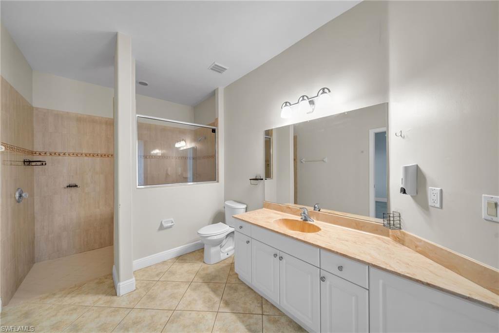 Full bathroom featuring vanity, light tile patterned floors, and a walk in shower