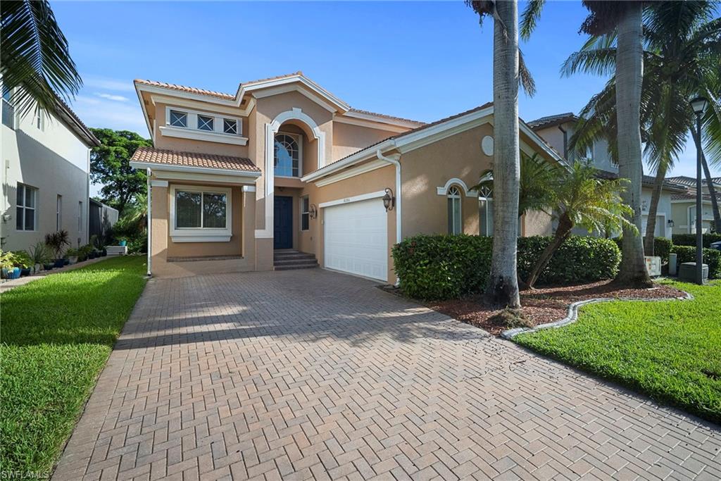 Mediterranean / spanish home with stucco siding, decorative driveway, a front yard, and a tiled roof
