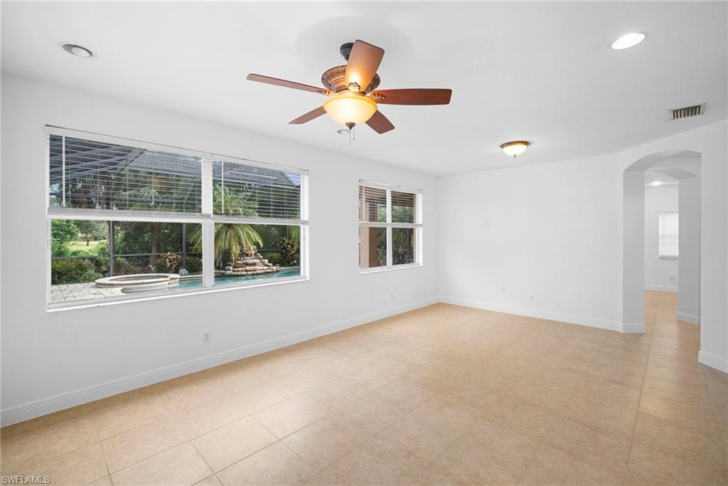 Family room with arched walkways, healthy amount of natural light, recessed lighting, and a ceiling fan