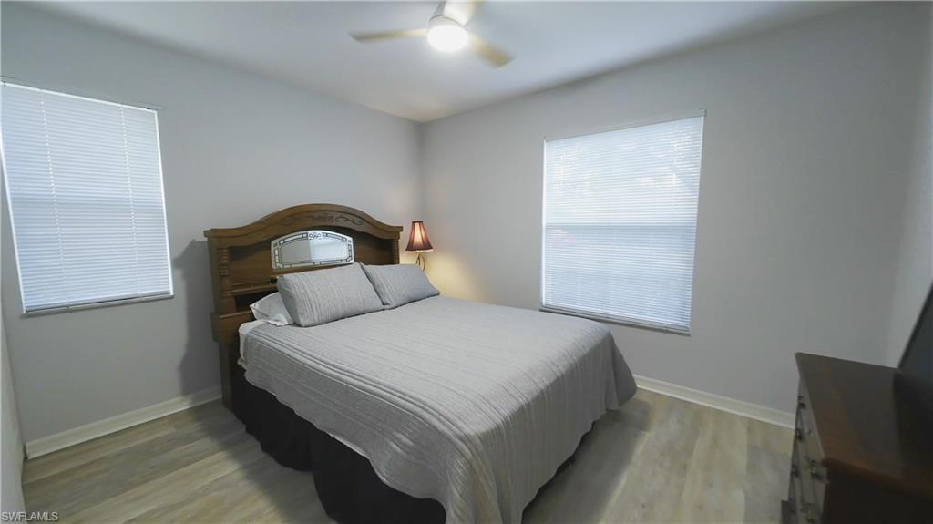 Room featuring wood-finish flooring, light gray wall paint, and white trim