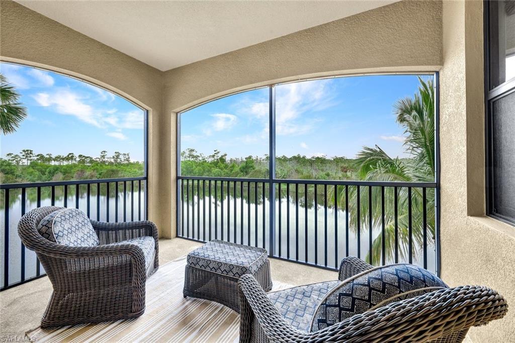 Sunroom featuring a water view and view of scattered trees
