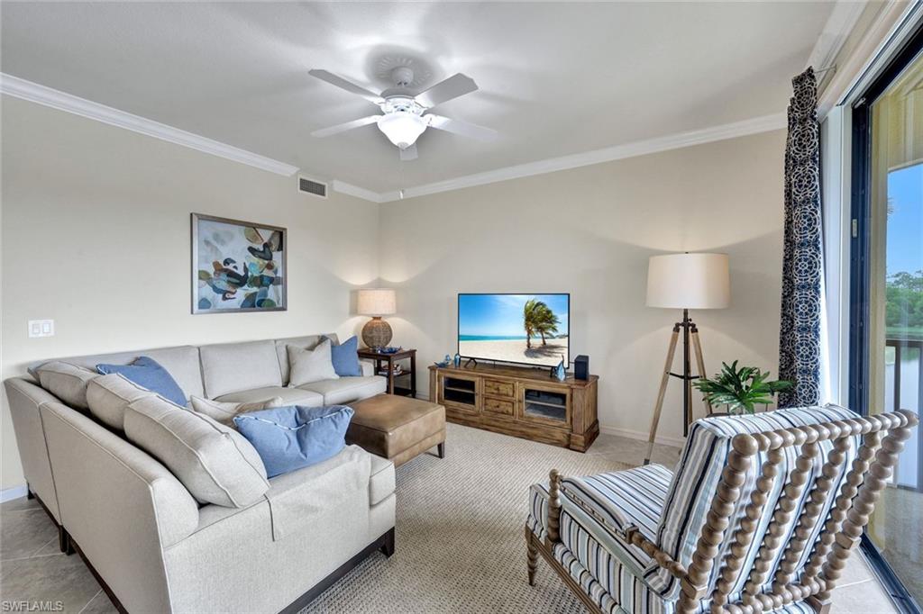 Carpeted living room with ornamental molding and a ceiling fan