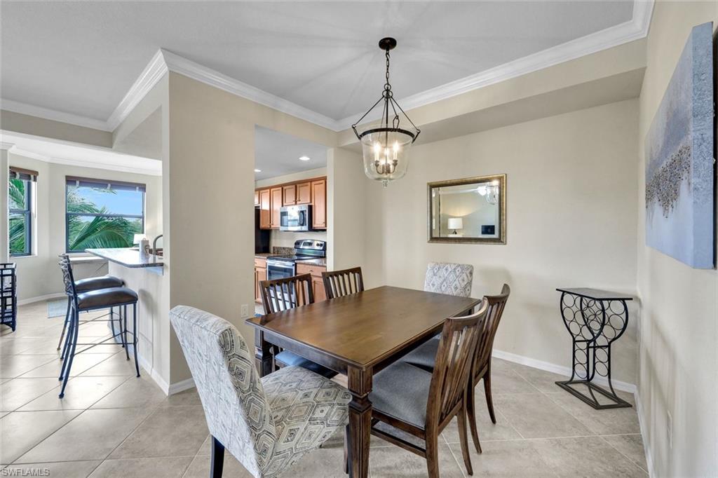 Dining area with light tile patterned flooring, crown molding, a chandelier, and recessed lighting