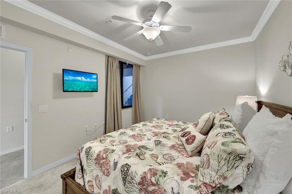 Bedroom with crown molding, light carpet, and ceiling fan