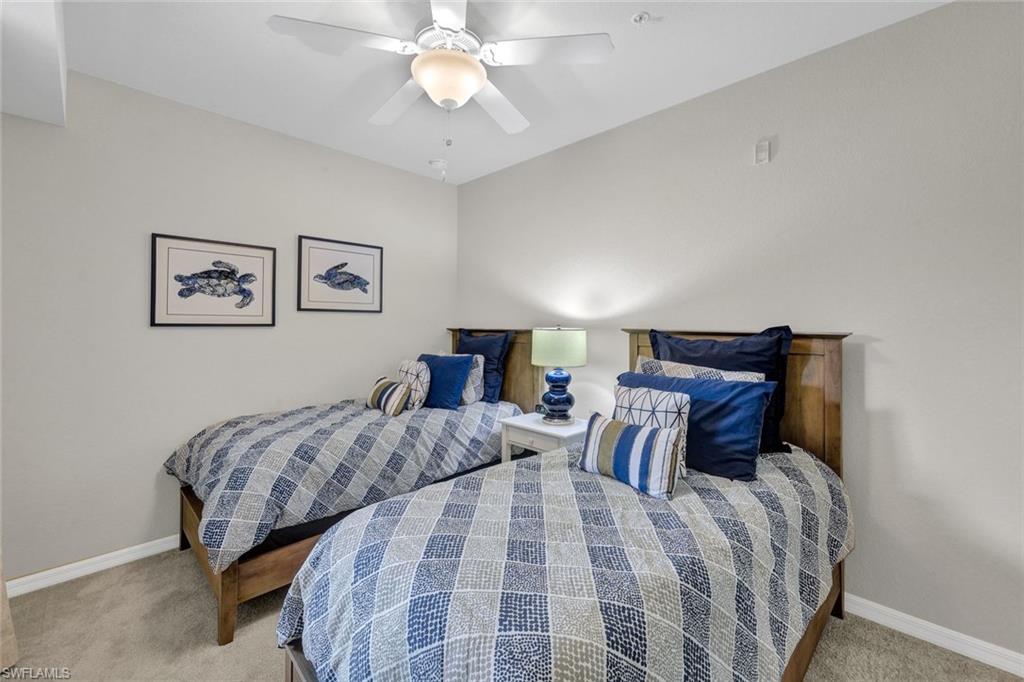 Bedroom with ceiling fan and light colored carpet