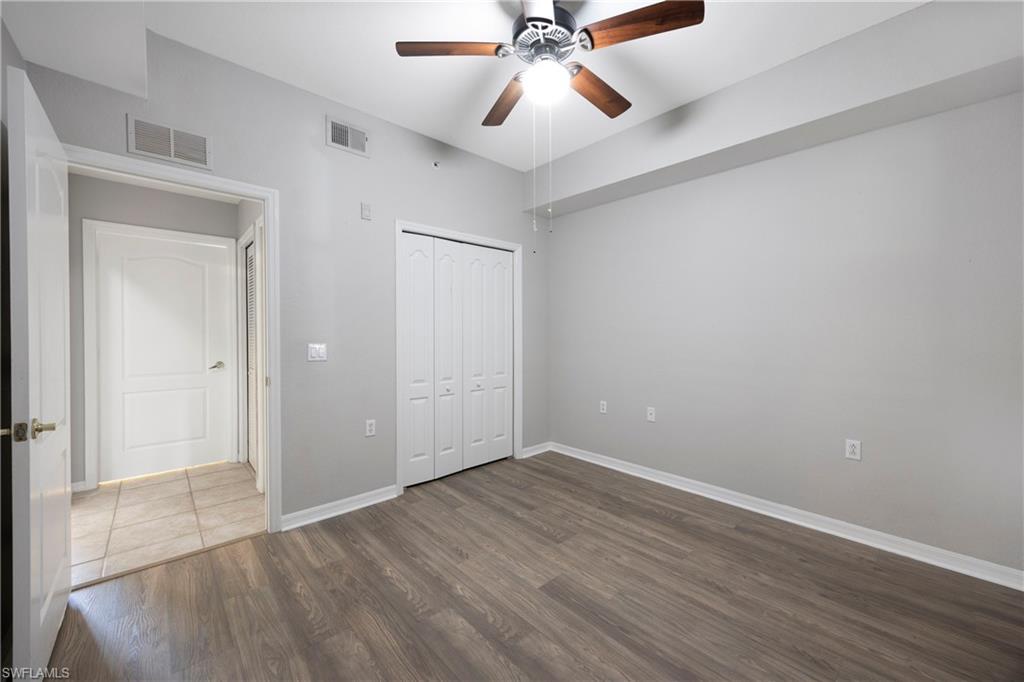 Unfurnished bedroom featuring wood finished floors, a ceiling fan, and a closet