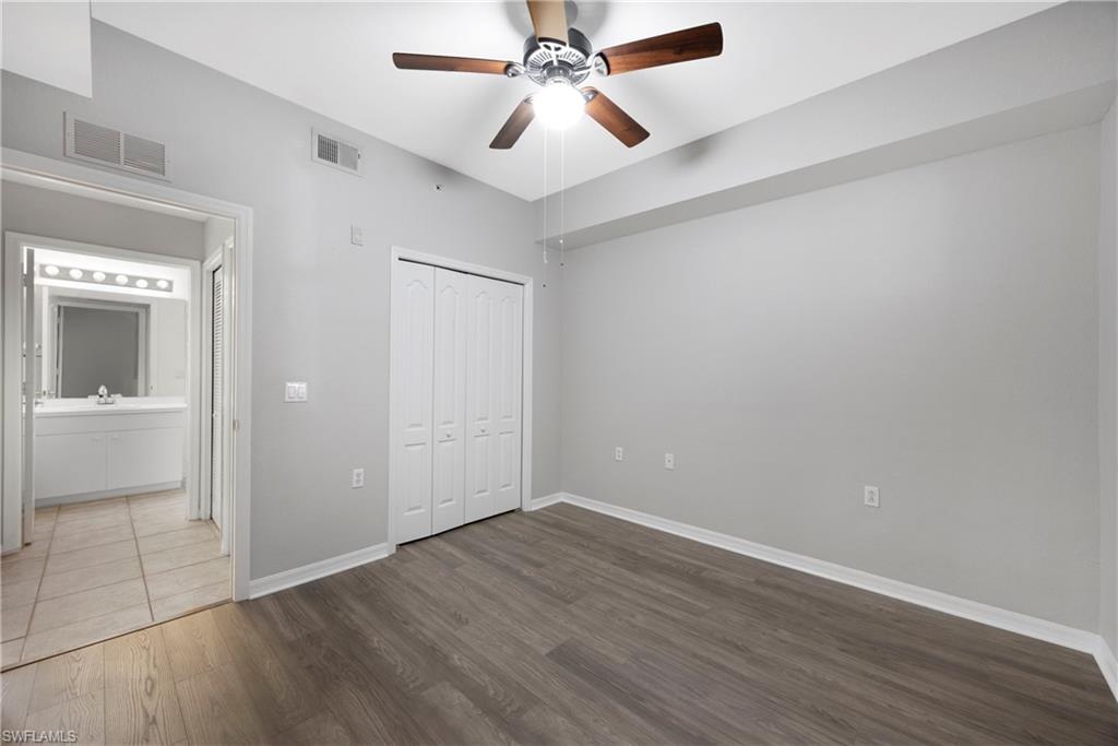 Unfurnished bedroom featuring dark wood-style floors, ceiling fan, and a closet
