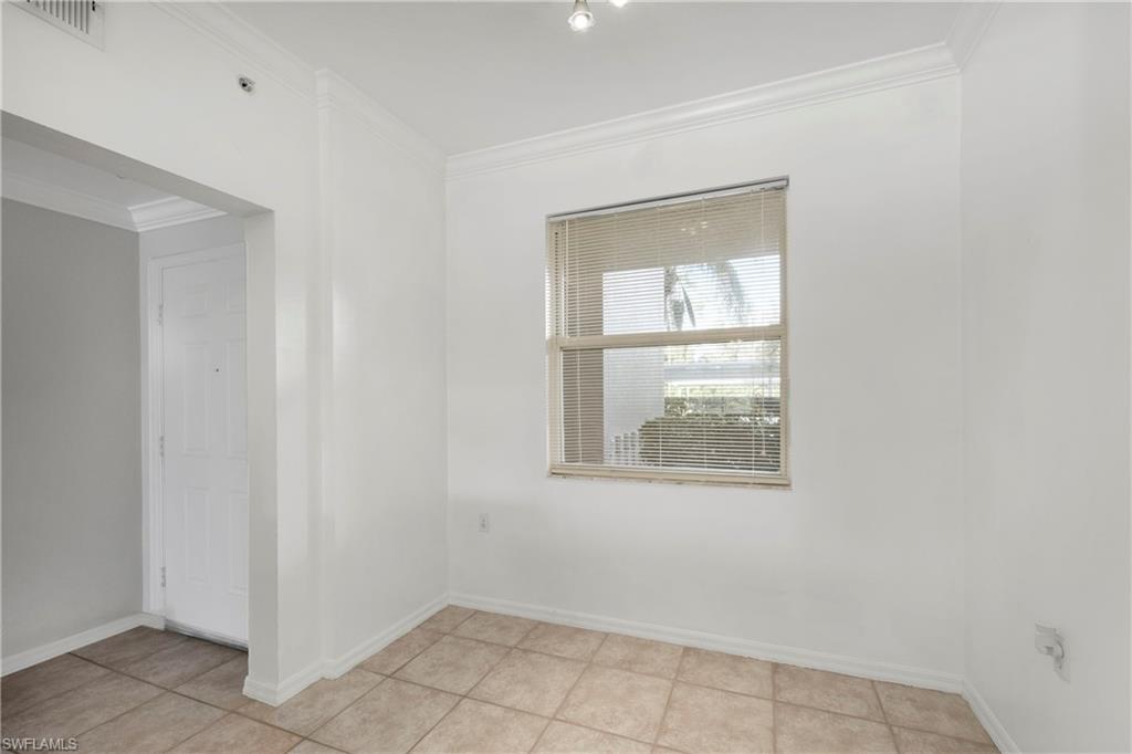 Spare room with ornamental molding and light tile patterned floors