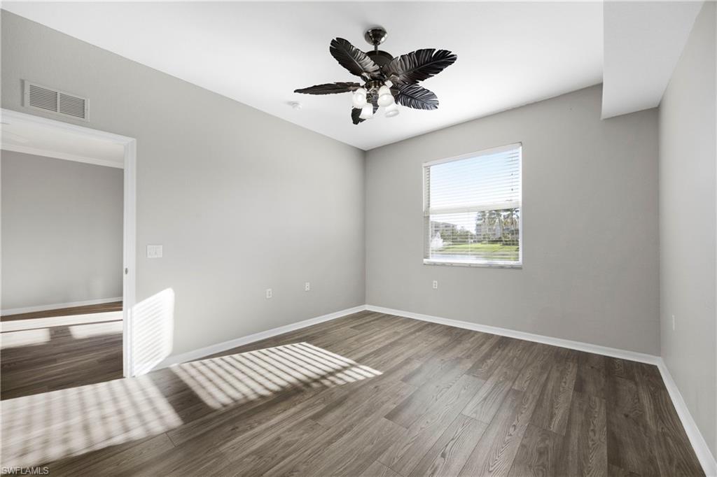 Unfurnished room featuring dark wood-style floors and ceiling fan