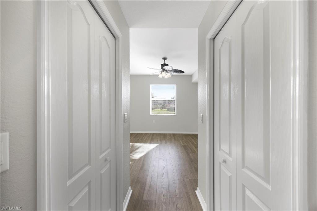 Hallway with baseboards and dark wood-type flooring
