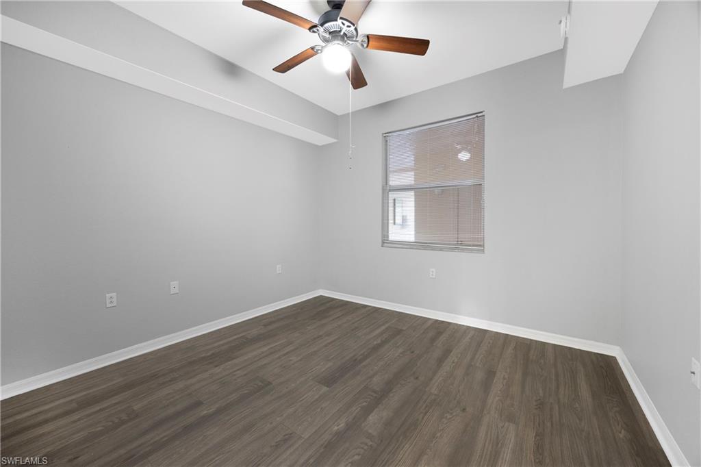 Spare room featuring dark wood finished floors and ceiling fan