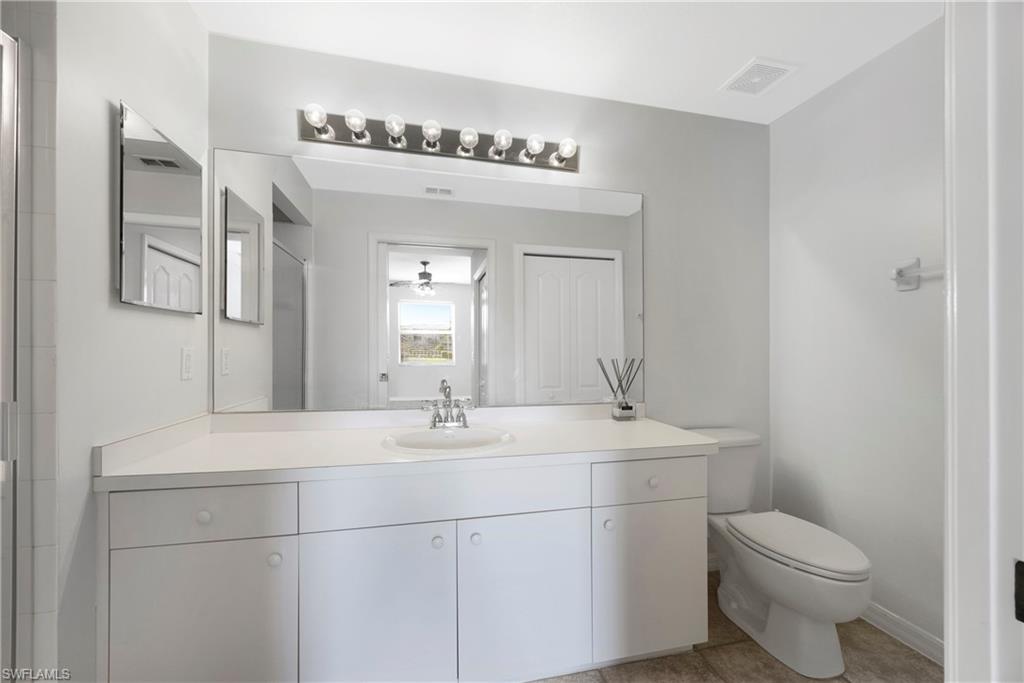 Full bath featuring vanity and light tile patterned flooring