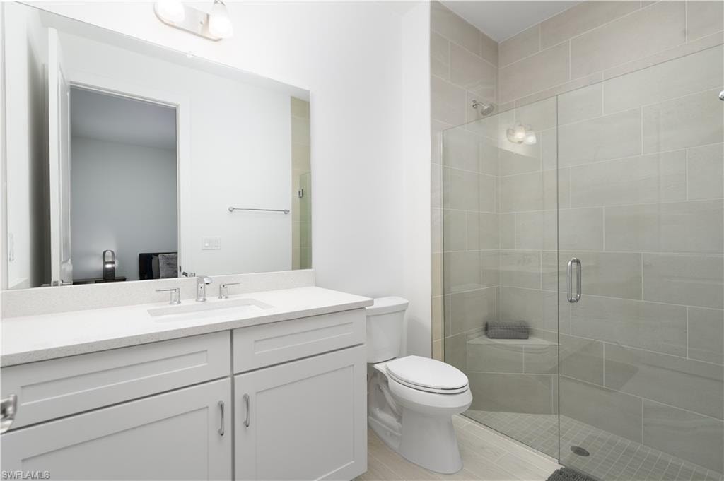 Bathroom with a stall shower, vanity, and light wood-style flooring