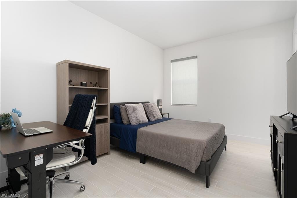 Bedroom with an office area and wood finish floors