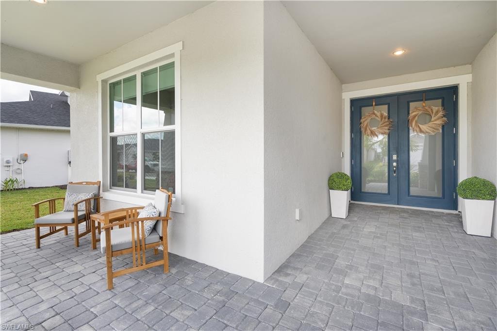 Doorway to property with stucco siding and french doors