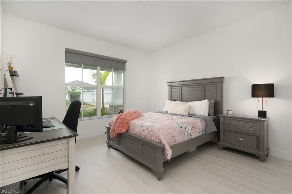 Bedroom featuring wood tiled floors and an office area