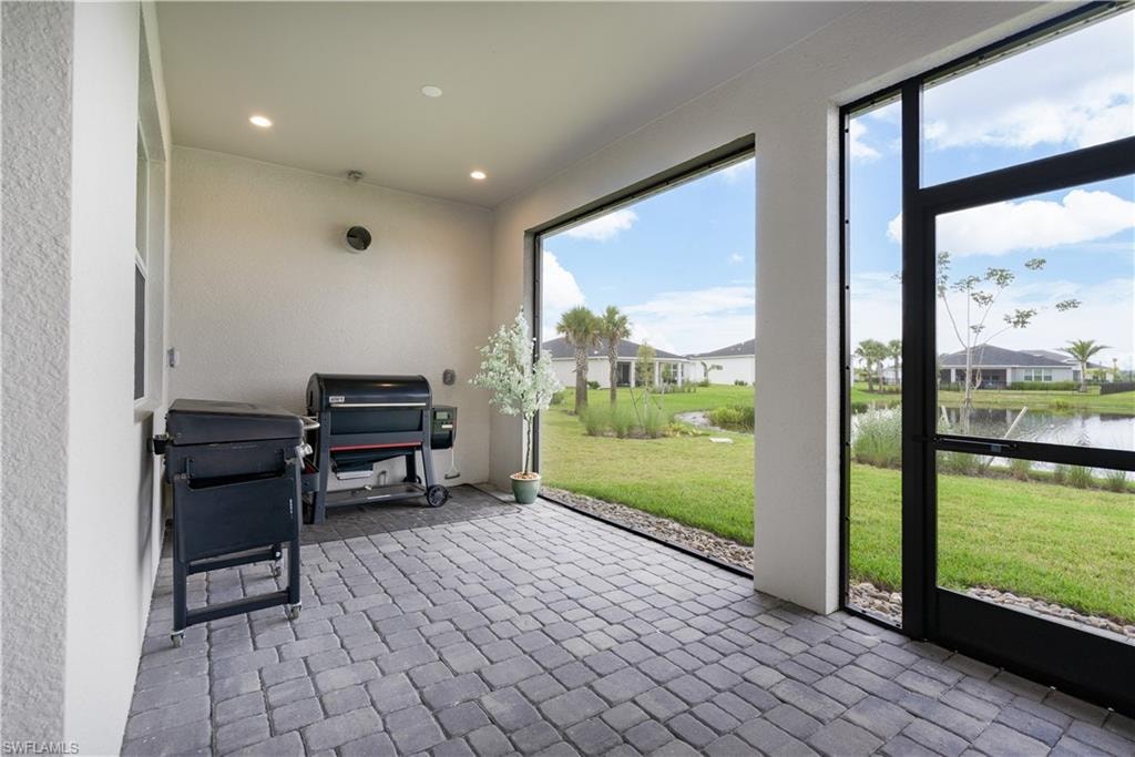 Sunroom / solarium featuring a water view and a residential view