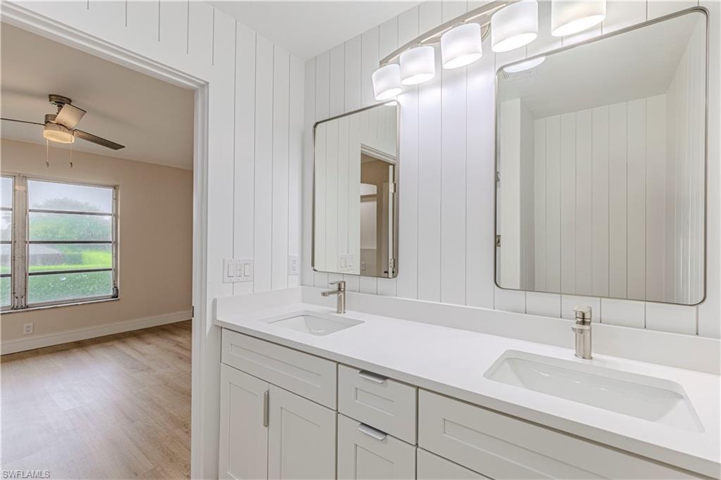 Full bathroom featuring double vanity and light wood finished floors