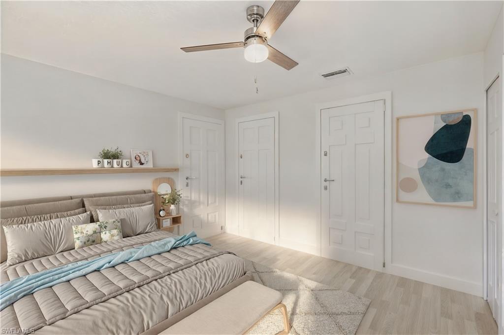 Bedroom featuring wood finished floors, a ceiling fan, and multiple closets
