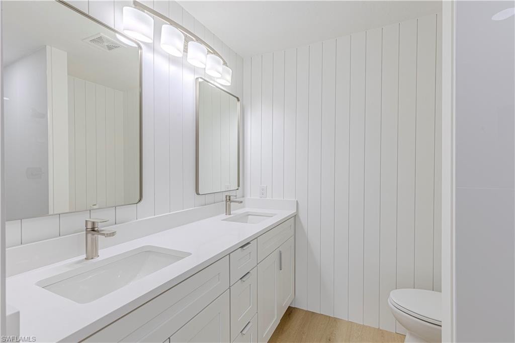 Full bath featuring double vanity and toilet